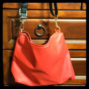 Red purse with black straps and gold hooks